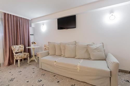 a hotel room with a bed and a tv on the wall at Klass Predeal in Predeal