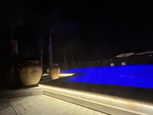 a swimming pool at night with two vases next to it at Villa Mare Di Montelusa in Agrigento