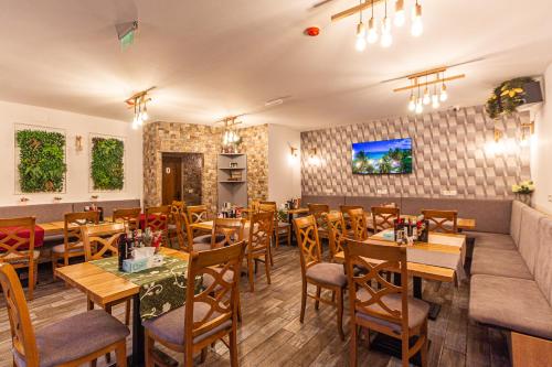 a restaurant with tables and chairs and a couch at Klass Predeal in Predeal