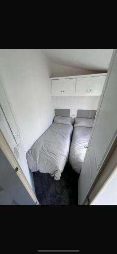 a small bedroom with two beds in a small room at Patricias Property in Sheerness
