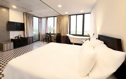 a hotel room with a large bed and a bathroom at TTR Skypool View Hotel in Da Lat