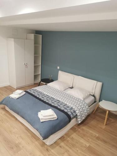 une chambre avec un grand lit avec des serviettes dessus dans l'établissement Superbe Loft d'artiste, à Romainville