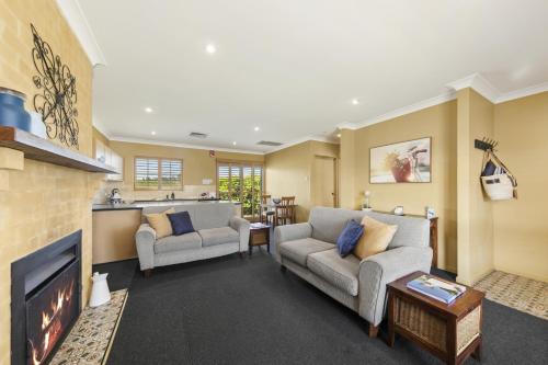 a living room with two couches and a fireplace at Broken View Estate in Pokolbin