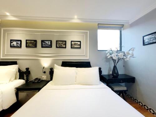 a bedroom with a large white bed and a window at TTR Skypool View Hotel in Da Lat