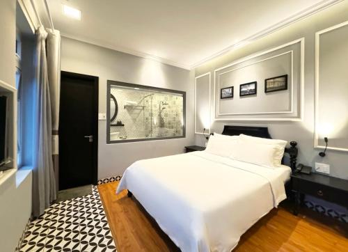 a bedroom with a large white bed in it at TTR Skypool View Hotel in Da Lat
