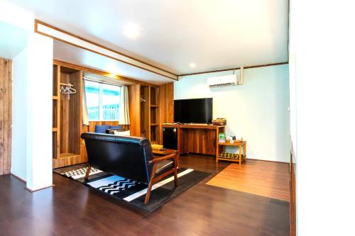 a living room with a chair and a television at Varni Homestay in Phatthalung
