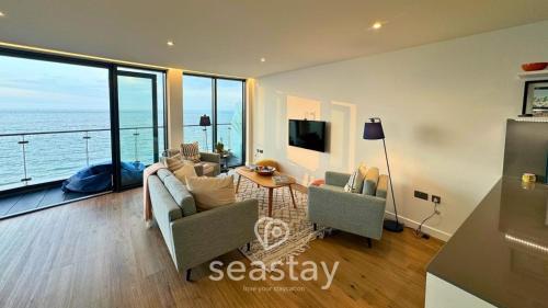 a living room with a view of the ocean at Sail Penthouse - Beach & Parking in Kent