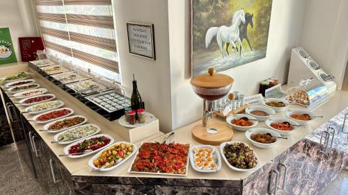 a buffet with many plates of food on a table at Hotel Santana in Altınoluk