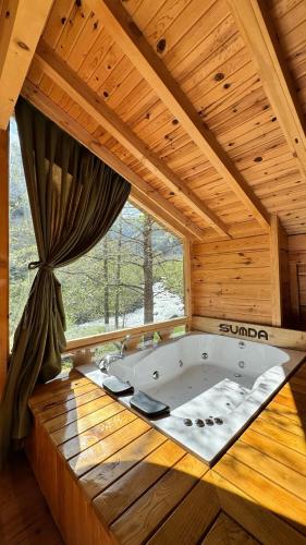 a large tub in a wooden room with a window at Sumda Konaklar in Çamlıhemşin