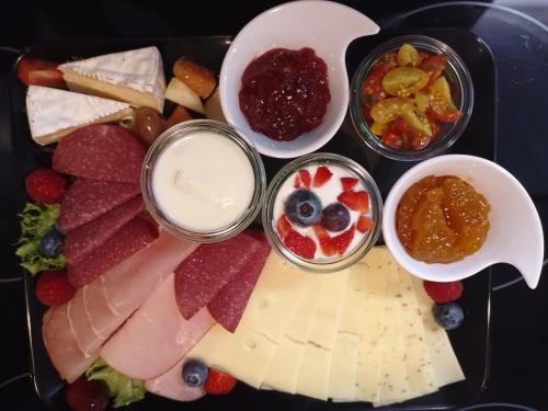 a plate of cheese and fruit with dip and dips at Pension Tiffany in Chemnitz