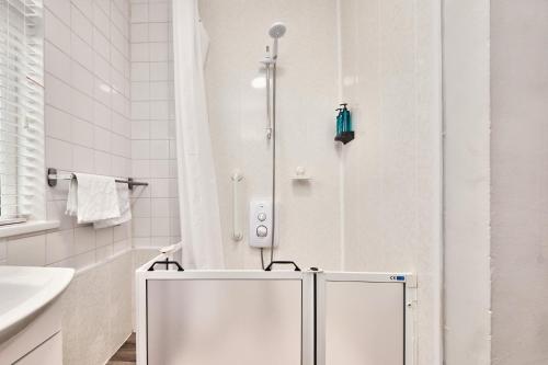 a white bathroom with a shower and a sink at Princess Yellow 1 - Portrush by the Sea in Portrush