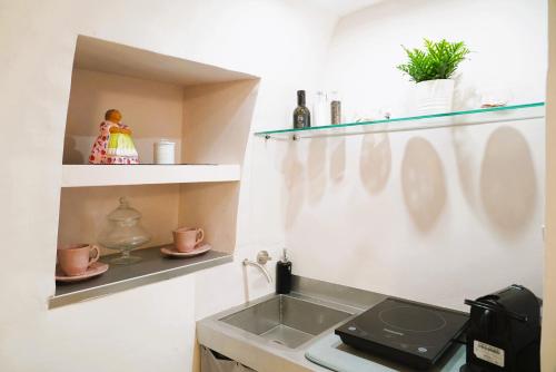 a kitchen with a sink and a stove at La Chianca Rosa - RIFUGIO ROMANTICO ad Ostuni in Ostuni