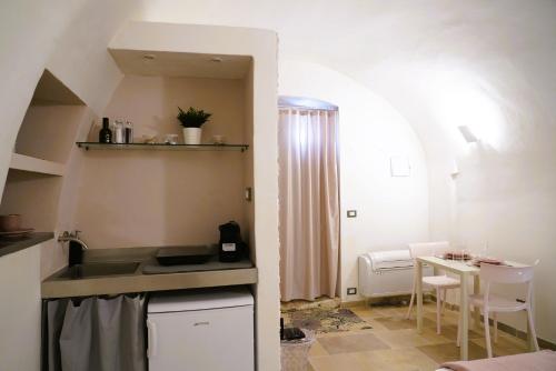 a small kitchen with a sink and a table at La Chianca Rosa - RIFUGIO ROMANTICO ad Ostuni in Ostuni