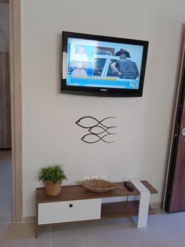 a flat screen tv hanging on a wall in a living room at Fish eye in Nikiti