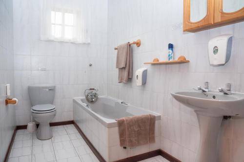 a white bathroom with a toilet and a sink at Kings Lodge Hotel in Hogsback