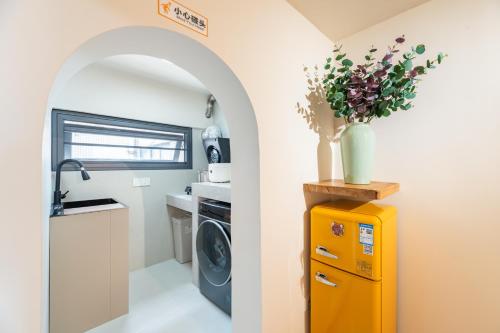 a kitchen with a washer and dryer in a tiny house at Guangzhou He She Art Apartment in Guangzhou