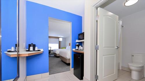 Holiday Inn Express & Suites Lexington Midtown - I-75, an IHG Hotel في ليكسينغتون: حمام به مرحاض وجدار أزرق