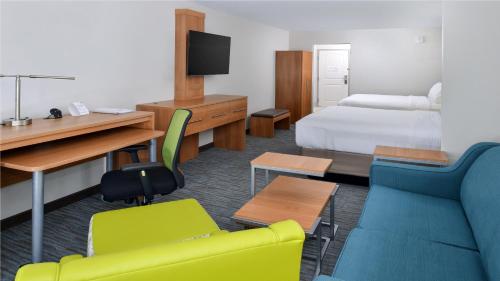 a hotel room with a bedroom with a bed and a desk at Holiday Inn Express & Suites Lexington Midtown - I-75 by IHG in Lexington
