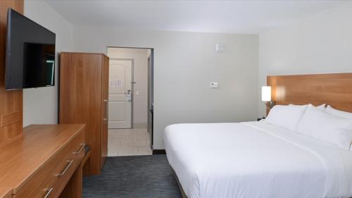a hotel room with a bed and a flat screen tv at Holiday Inn Express & Suites Lexington Midtown - I-75 by IHG in Lexington