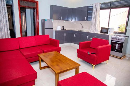 a living room with red furniture and a kitchen at BUJUMBURA Appart in Bujumbura