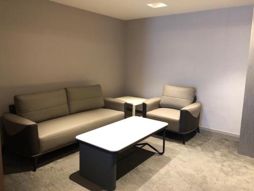 a waiting room with a couch and a chair at 麗隆商旅LilongHotel in Kaohsiung