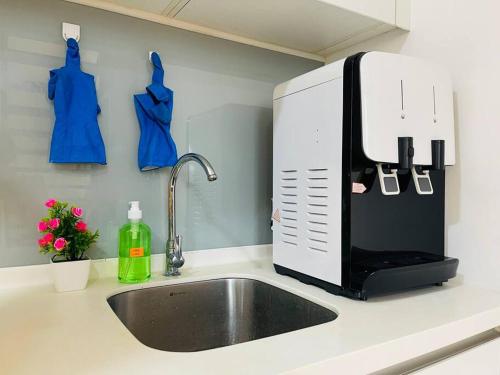 a kitchen counter with a sink and a microwave at Eko Cheras Duplex by DeUrban in Kuala Lumpur