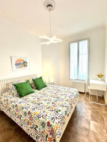 une chambre avec un lit avec un couvre-lit fleuri dans l'établissement Villa Lila Nice, à Nice
