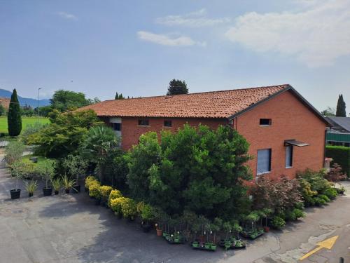 a red brick house with a lot of plants at Agriturismo Il Vivaio in Bergamo