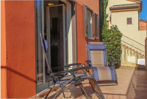 une chaise assise sur le côté d'un bâtiment dans l'établissement Joli appartement en Corse avec piscine, à Belgodère