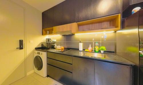 a kitchen with a sink and a washing machine at Axon Residence KLCC - KL HOME in Kuala Lumpur