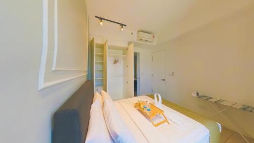 a person is pointing at a bed in a room at Axon Residence KLCC - KL HOME in Kuala Lumpur