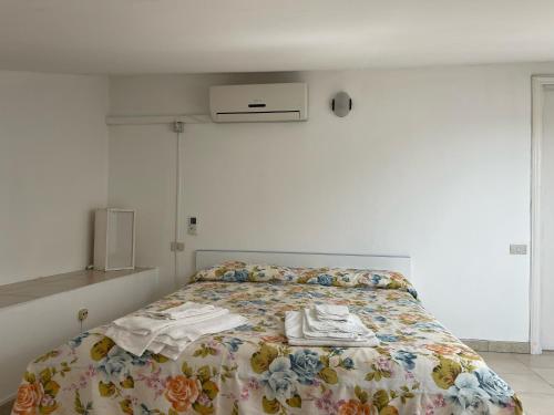 a bedroom with a bed with a floral comforter at Hotel Villa Degli Aranci in Maratea