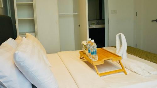 a bedroom with a white bed with a table on it at Axon Residence KLCC - KL HOME in Kuala Lumpur