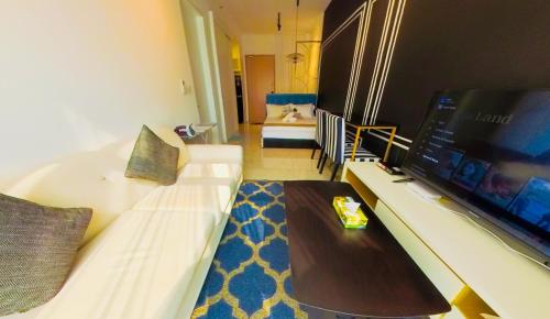 a living room with a white couch and a tv at Axon Residence KLCC - KL HOME in Kuala Lumpur