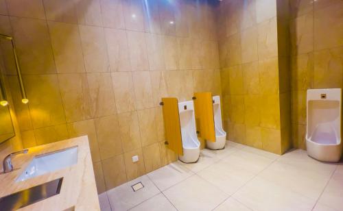 a bathroom with three toilets and three urinals at Axon Residence KLCC - KL HOME in Kuala Lumpur