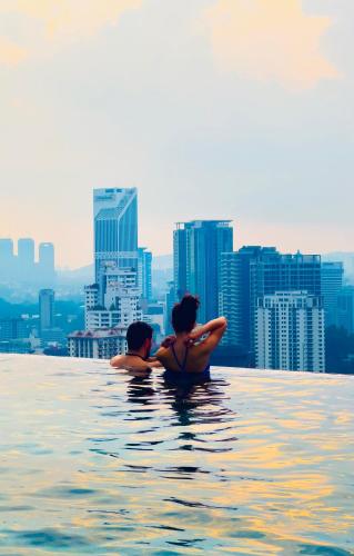 a man and a woman sitting in the water in the city at Axon Residence KLCC - KL HOME in Kuala Lumpur