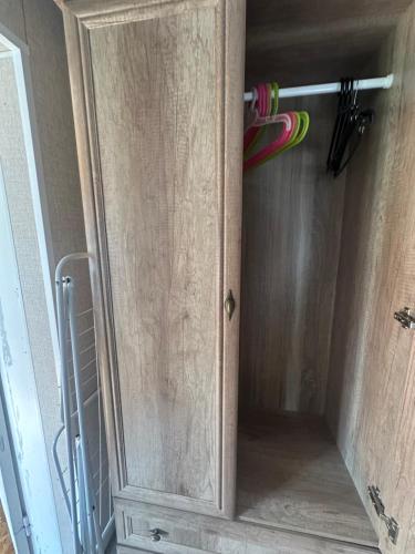 a wooden cabinet with a door in a room at Stāķi in Alūksne