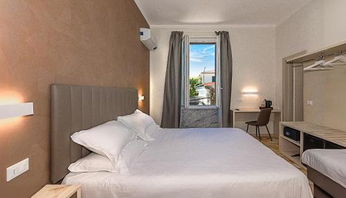 a bedroom with a white bed and a window at Villa Gioietta in Marina di Massa