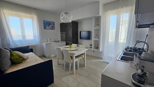 a kitchen and living room with a table and a couch at Blue Hole b&b Santeramo in colle e Jacuzzi Suite in Santeramo in Colle