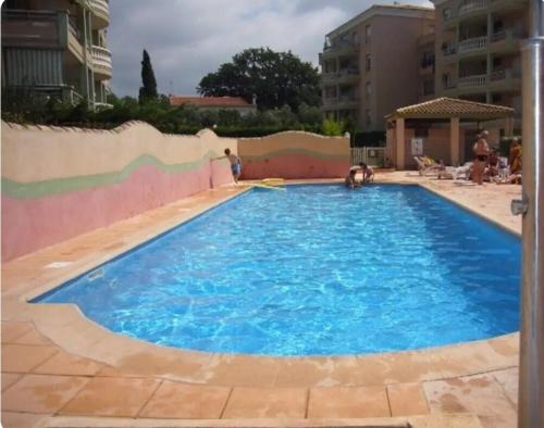 une grande piscine bleue avec des gens dedans dans l'établissement Gemütliches Studio, Pool, Parkplatz. Ohne Vis-a-vis., à Fréjus