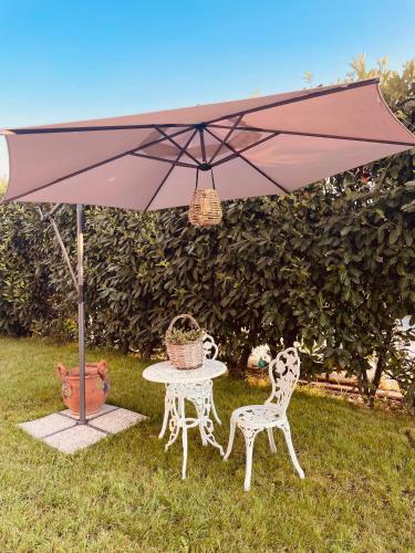a table and two chairs under an umbrella at Ca del Gno in Luni