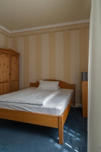 a bed in a room with a striped wall at Landhaus Arnoth in Kleinich