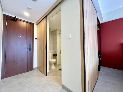 a bathroom with a toilet and a wooden door at Anaya Hotel Canggu in Canggu