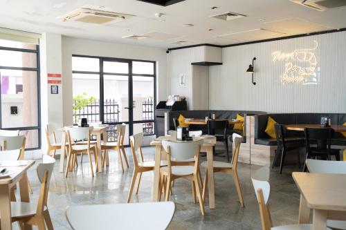 a dining room with tables and chairs and windows at Manhattan Business Hotel, Male in Male City