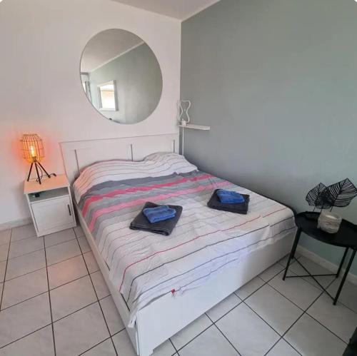 une chambre avec un lit avec un miroir et une chaise dans l'établissement Gemütliches Studio, Pool, Parkplatz. Ohne Vis-a-vis., à Fréjus