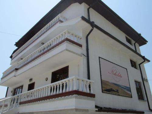 a large white building with a balcony on top of it at Вила Николета in Sveti Vlas