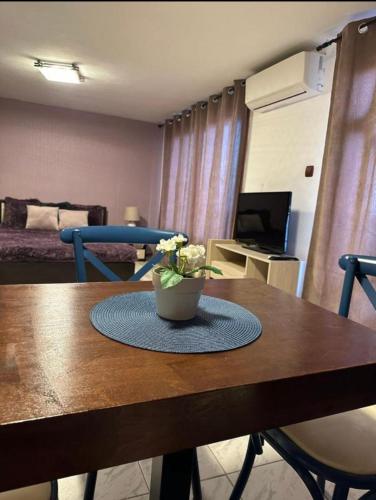a room with a table with a vase of flowers on it at Вила Николета in Sveti Vlas