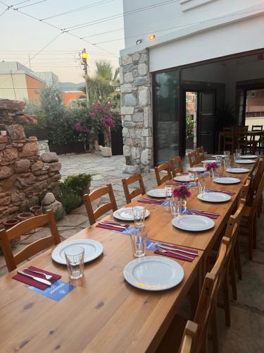 a long wooden table with chairs and plates on it at AGON Ephesus in Selcuk