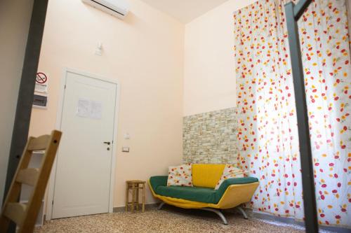 a room with a green chair and a wall at I VACANZIERI in Avola