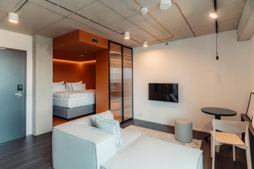 a living room with a white couch and a bed at HONEST Ricany in Ricany